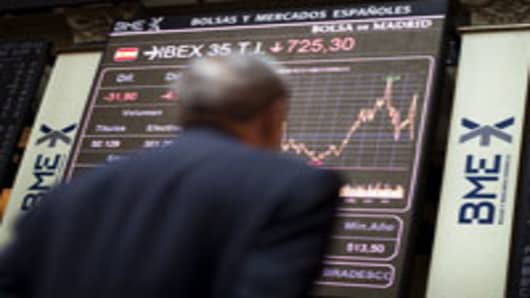 A trader looks at a display board showing information on the stock index, at the Madrid Stock Exchange in Madrid, Spain.