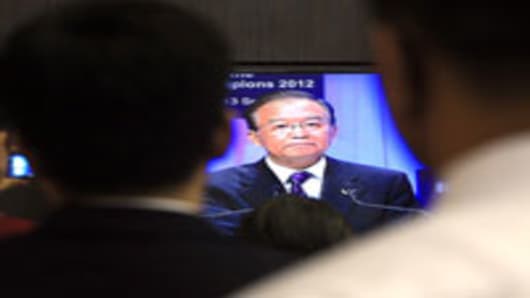 People watch an image presented on a television of Wen Jiabao, China's premier, speaking at the opening plenary session of the World Economic Forum (WEF) Annual Meeting of the New Champions in Tianjin, China, on Tuesday, Sept. 11, 2012.