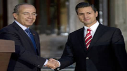 Mexican outgoing president Felipe Calderon (L) shakes hands with president elect Enrique Pena Nieto (R) after a private meeting at Los Pinos presidential residence on September 5, 2012 in Mexico City. Pena nieto said that he will try to mantain the country's stability avoiding to cut public policies of the presnt administration.