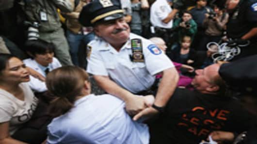 Protestors affiliated with Occupy Wall Street are arrested by NYPD officers while attempting to form a ‘Peoples Wall’ to block Wall Street on September 17, 2012 in New York City. Today is the one year anniversary of Occupy Wall Street and protestors are planning various actions and events throughout the day.
