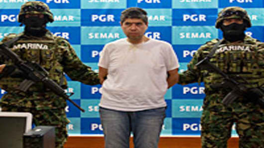 Mexican marines present to the press the alleged member of Zetas drug cartel Eric Jovan Lozano Diaz (C), aka 'Cucho', and some money seized during his arrestation in Mexico city, on June 15, 2012.