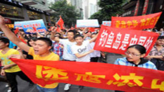 Chinese demonstraters carry anti-Japan banners and shout slogans during a protest over the Diaoyu islands issue, known as the Senkaku islands in Japan, in Chongqing, China.