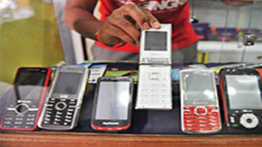 An Indian shopkeeper shows China Mobile phones in his mobile phone outlet in Hyderabad.