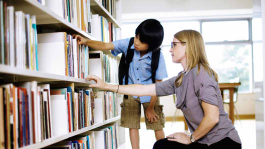 Boy and teacher in library