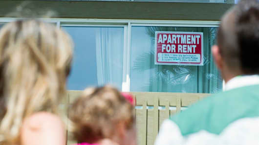 Family looks at apartment for rent sign