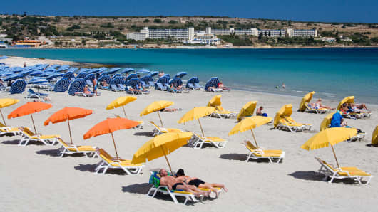Malta, Mellietha Bay, Tourists sunbathing on beach.