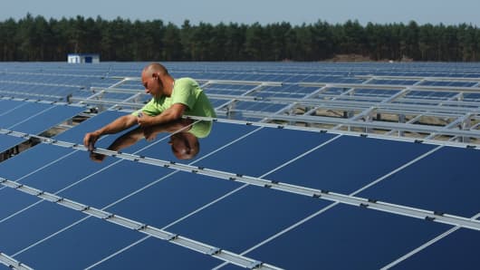 A worker installs solar panels at the Lieberose Solar Park on the park's partial inauguration day August 20, 2009 in Lieberose, Germany.