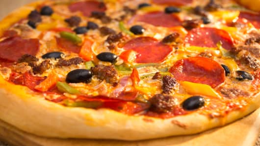Pizza with sausage, pepperoni, bell peppers, cheese and olives.
