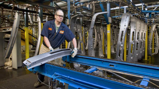 Auto parts production workers work on a production lines making both metal and plastic bumpers.