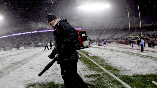 Workers clear snow from the field before Minnesota Vikings play the Chicago Bears at TCF Bank Stadium on December 20, 2010 in Minneapolis, Minnesota.
