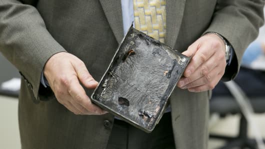 Joseph Kolly, Director of research and engineering with the National Transportation Safety Board holds a damaged battery cell case from a Japan Airlines Co. (JAL) Boeing Co. 787 Dreamliner at the NTSB materials laboratory in Washington, D.C.