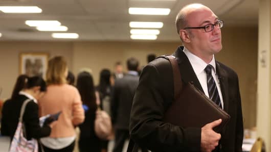 An applicant stands after meeting potential employers at a job fair in New York.
