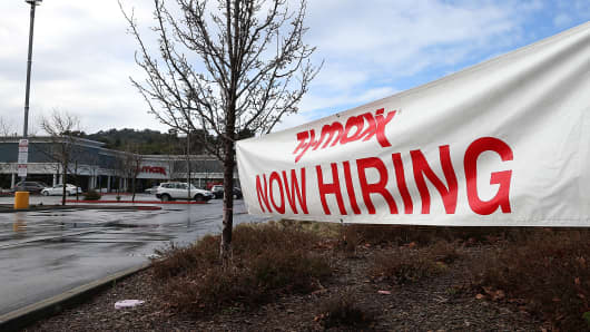 A sign advertising jobs is posted in fromt of a TJ Maxx store in San Rafael, California.