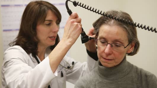 A doctor checks a patient who is experiencing flu symptoms.