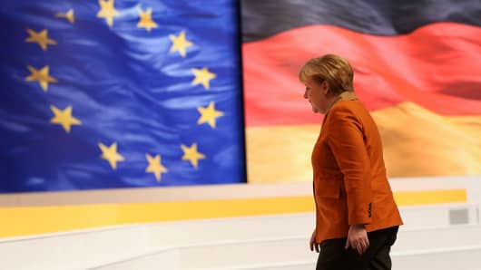 German Chancellor Angela Merkel,  walks past flags of the European Union and Germany.