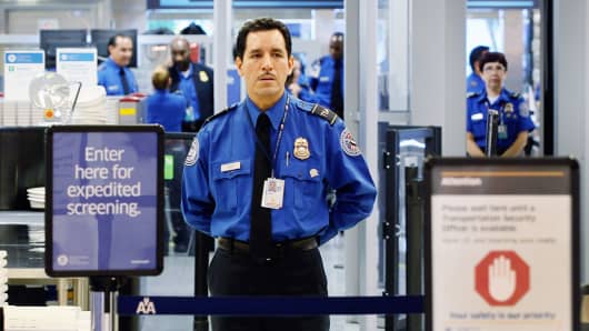 A TSA agent waits for passengers at the Miami International Airport.