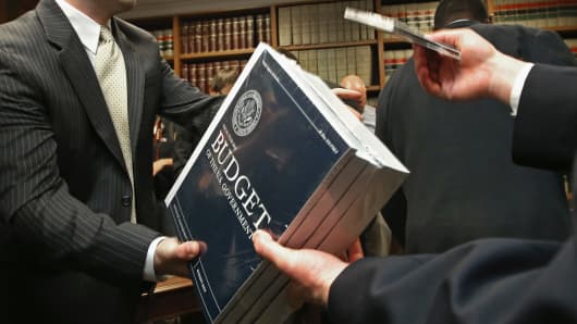 Senate Budget Committee staff members hand out copies of the Obama Administration's proposed FY 2014 federal budget in the Dirksen Senate Office Building on Capitol Hill.