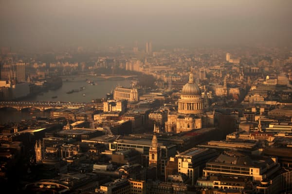 A view over the financial district and St Paul's Cathedral towards the west of the city at sunrise in London.