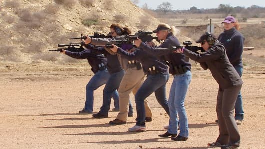 Women at a women's gun club fire AR-15 assault rifles.
