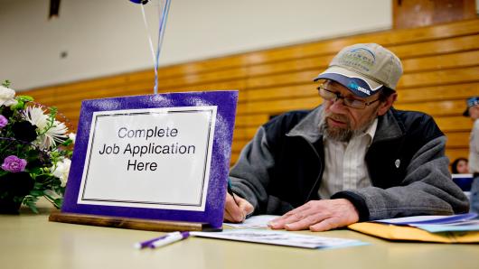 Job seeker Clinton Crouch, who said he was laid-off in Sept. 2011, fills out an application for a maintenance job during a job fair at Illinois Valley Community College (IVCC) in Oglesby, Illinois, U.S.
