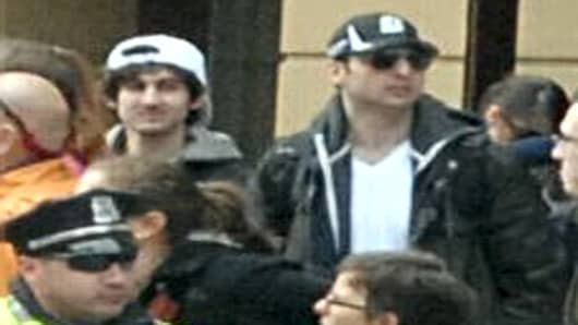 The two suspects in the Boston Marathon bombing walk near the marathon finish line.