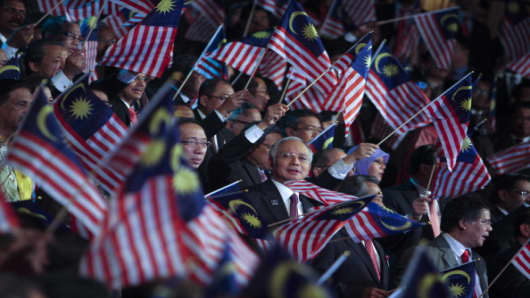 Malaysian Prime Minister Najib Razak and his staff wave Malaysian flags.