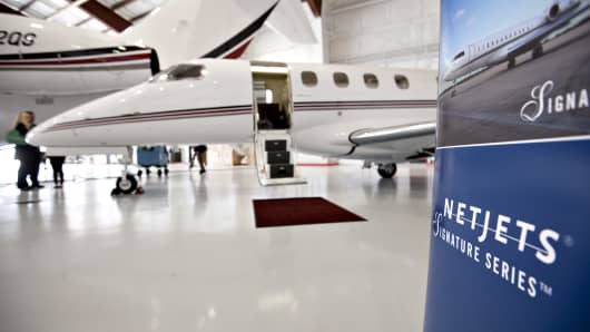 A Netjets Inc. sign stands hear a new Embraer Phenom 300 jet at Eppley Airfield in Omaha, Nebraska, U.S.