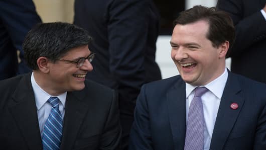 Jacob 'Jack' Lew, U.S. treasury secretary, left, and George Osborne, U.K. chancellor of the exchequer, laugh while posing for the family photo during the Group of Seven (G-7) finance ministers and central bank governors meeting at Hartwell House in Aylesbury, U.K.