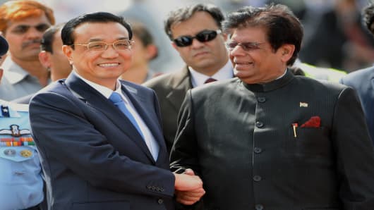 Chinese Premier, Li Keqiang (L) is welcomed by Indian Minister of State for External Affairs, E. Ahmed on his arrival at Palam Airport in New Delhi on May 19, 2013