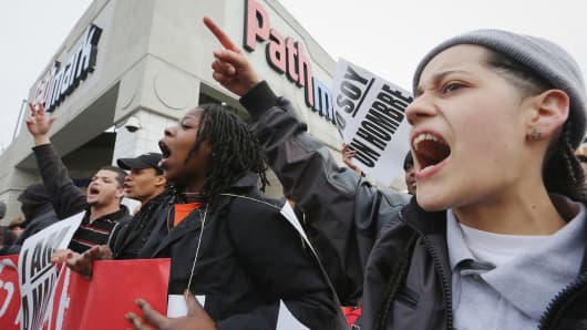 People hold signs during a protest for better wages for fast food workers.