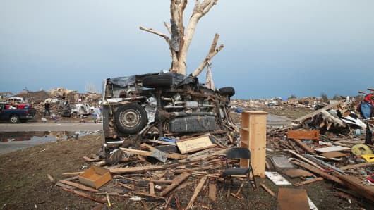 A pickup truck is wrapped around a tree after a powerful tornado ripped through Moore, Oklahoma.