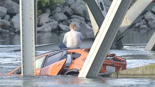 An unidentified man waits on his submerged vehicle in the Skagit River on Thursday.