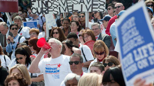 People cheer at a rally for medical research where more than 170 partnering organizations 'called on our nation's policymakers to make lifesaving medical research funding a national priority.'