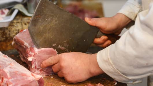 A butcher chops pork at a market in Shanghai, China on May 30, 2013.