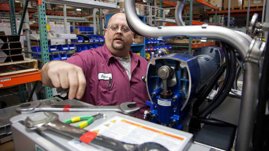 Systems electrical assembler Kevin Quick replaces the motor in an integrated reactor machine that sprays insulation in homes at the Graco Inc. manufacturing facility in Minneapolis, Minnesota.