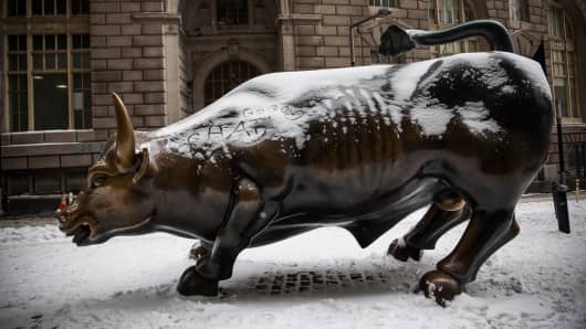 The Wall Street Bull, officially called Charging Bull, is covered in snow the morning after a snowstorm in New York City.