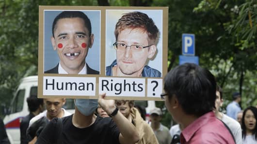 A man holds up a protest sign during the protest rally to support Edward Snowden in Hong Kong on June 15, 2013.