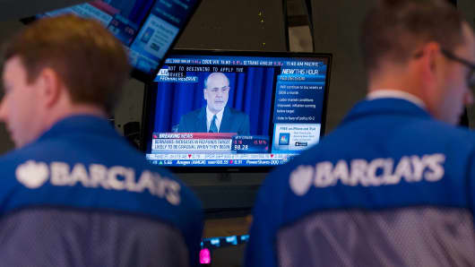 Traders work on the floor of the New York Stock Exchange (NYSE) as Ben S. Bernanke, chairman of the U.S. Federal Reserve, speaks on television in New York, U.S.