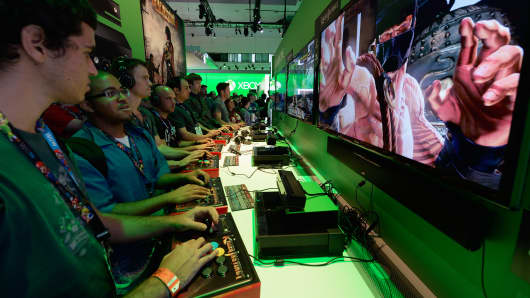 Gamers play a game on the Xbox One console in the Microsoft Xbox booth during the Electronics Expo at the Los Angeles Convention Center.