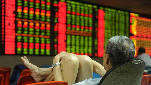 An investor watches the electronic board at a stock exchange hall in Hefei, China.
