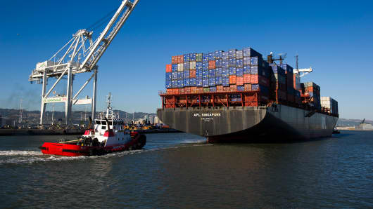 A tug boat moves the APL Singapore container ship to dock at the Port of Oakland in Oakland, California, U.S.
