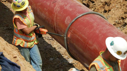 Workers install a natural gas pipeline.