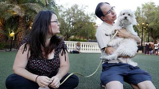 Skye Pearce and Bryan Haas play with their dog, Lucky. The couple says the dog helps fill the void of not having kids.