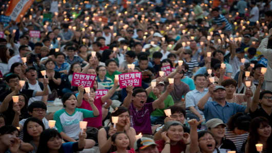 Protesters shout slogans condemning South Korean National Intelligence Service involvement in the country's last presidential elections, during a demonstration outside the Seoul city hall.