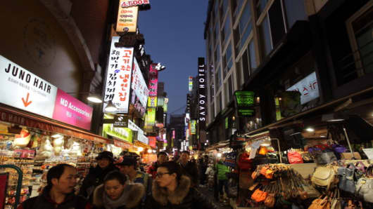 Shoppers walk in the Myungdong shopping district in Seoul, South Korea.