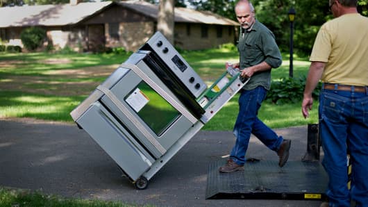 Valley Appliance employees Dennis Husser, left, and Dan Arkels deliver a Maytag Corp. electric stove to a customer in Princeton, Illinois, U.S.