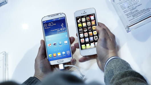 A Samsung Galaxy S4 smartphone, left, next to an Apple iPhone 5