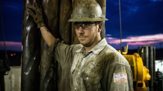 A derrick hand works on an oil rig drilling into the Bakken shale formation outside Watford City, North Dakota.