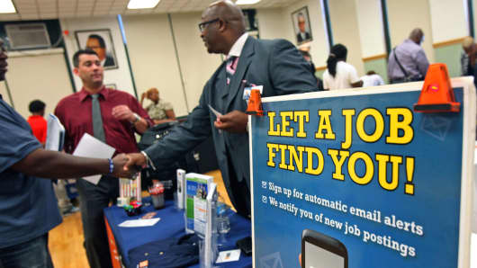 Job seekers speak with an employer at a job fair in Chicago.