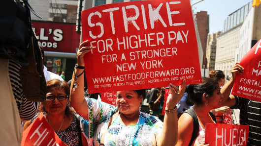 Fast-food workers demand higher pay at a protest outside a Wendy's in New York in July.